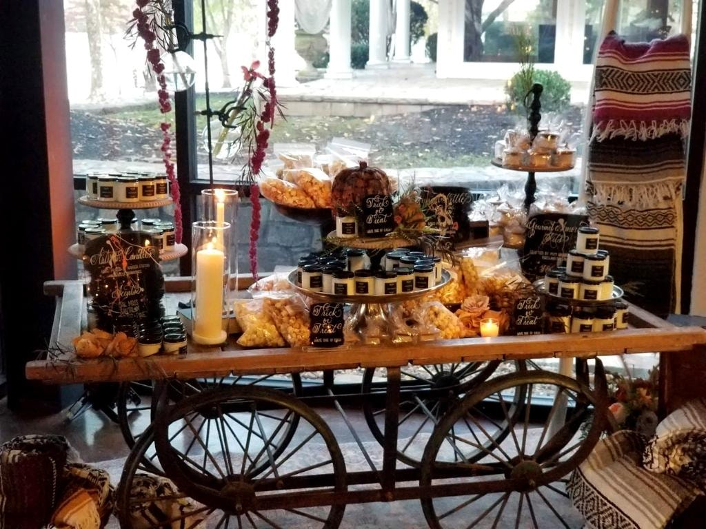 Fall vendor cart with artisan candles, popcorn, and gourmet goods