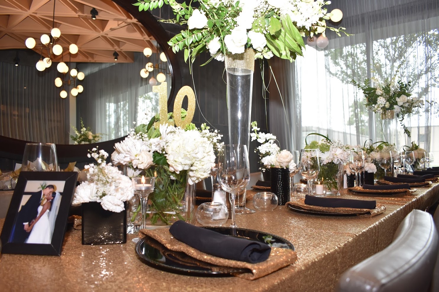 Gold sequin banquet table closeup with white florals and tall centerpiece