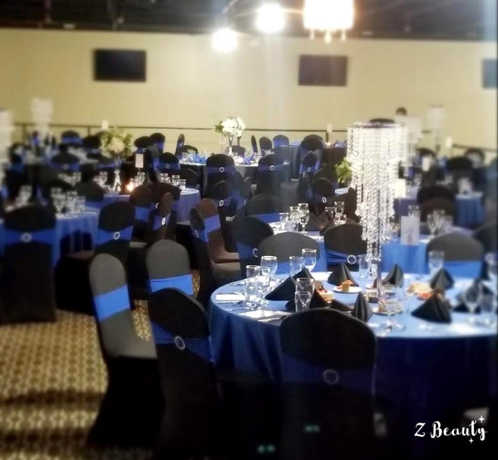 Royal blue gala banquet hall with black chair covers and crystal centerpieces
