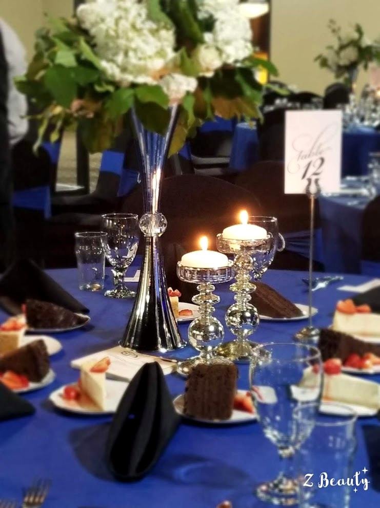 Royal blue place setting with floating candles and white floral centerpiece