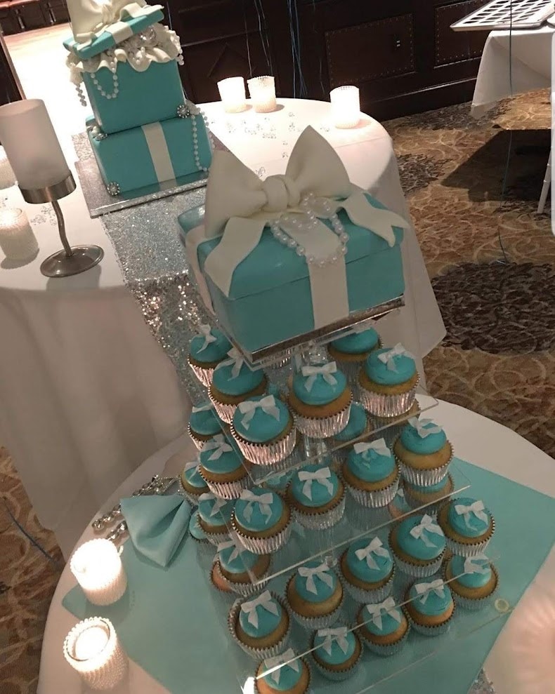 Tiffany blue cupcake tower with box cake and white bow on glitter table