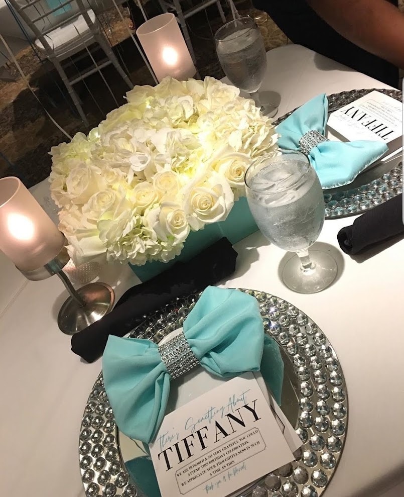 Tiffany themed tablescape with white rose and hydrangea centerpiece and bow napkins