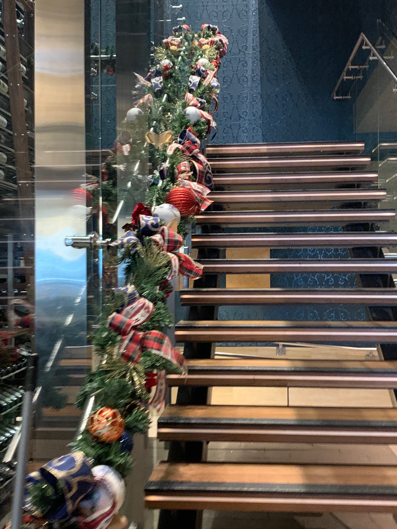 Plaid and ornament garland draped over modern staircase railing