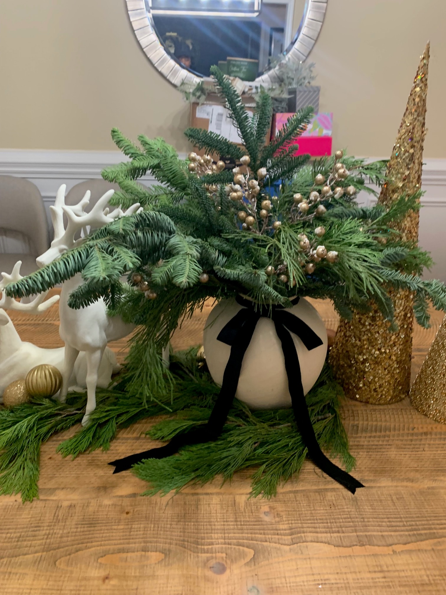 White reindeer vignette with fresh greenery and gold ornaments